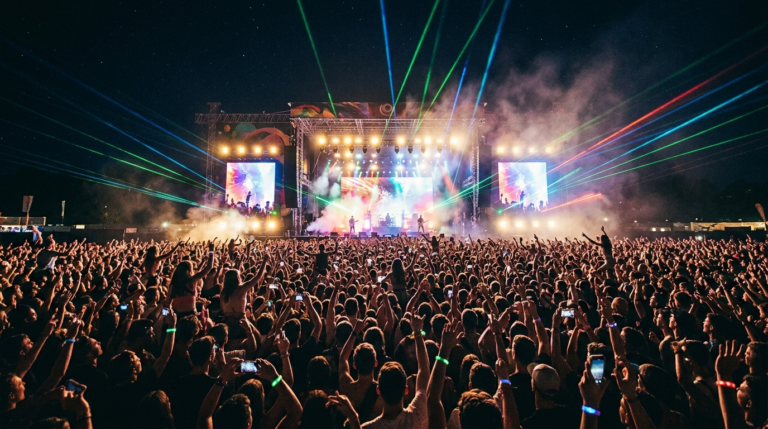 Rzeszowskie Juwenalia 2026 w Polsce. Nocny festiwal w Rzeszowie, kolorowe lasery i wiwatujący tłum ludzi z rękami w górze pod rozświetloną sceną.